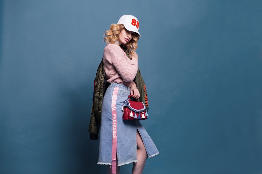 Trendy fashion model poses in a stylish studio setting, showcasing a chic outfit with accessories.